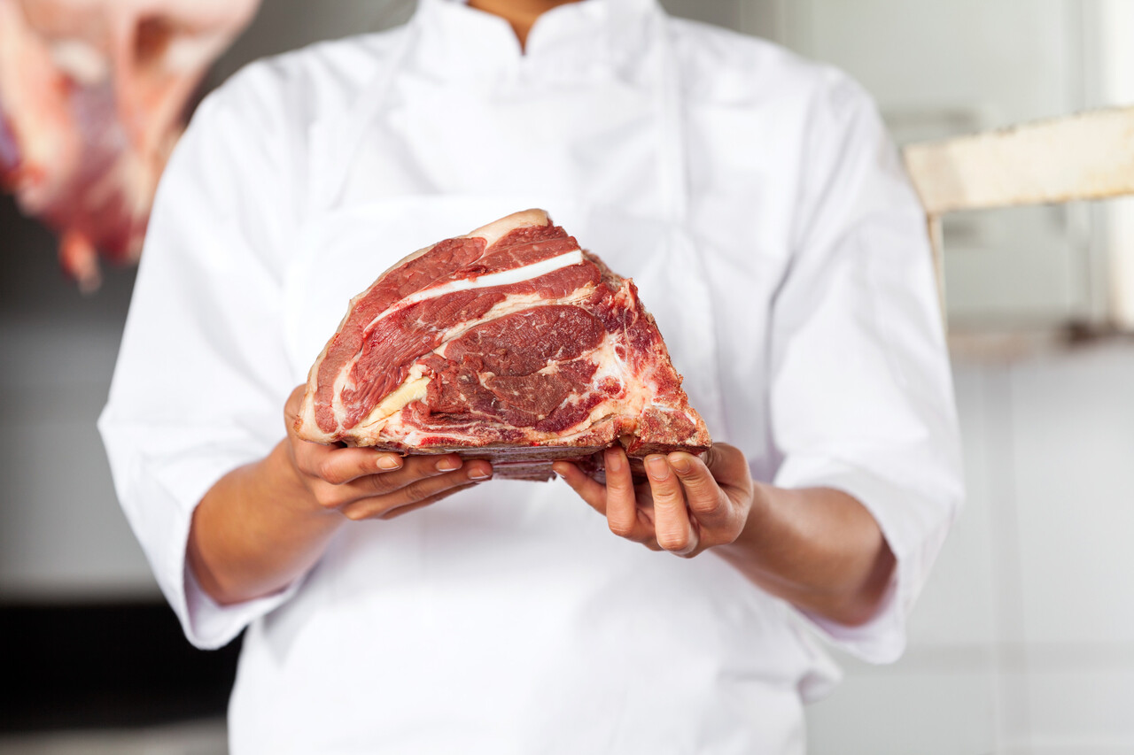 Midsection Of Butcher Holding Steak