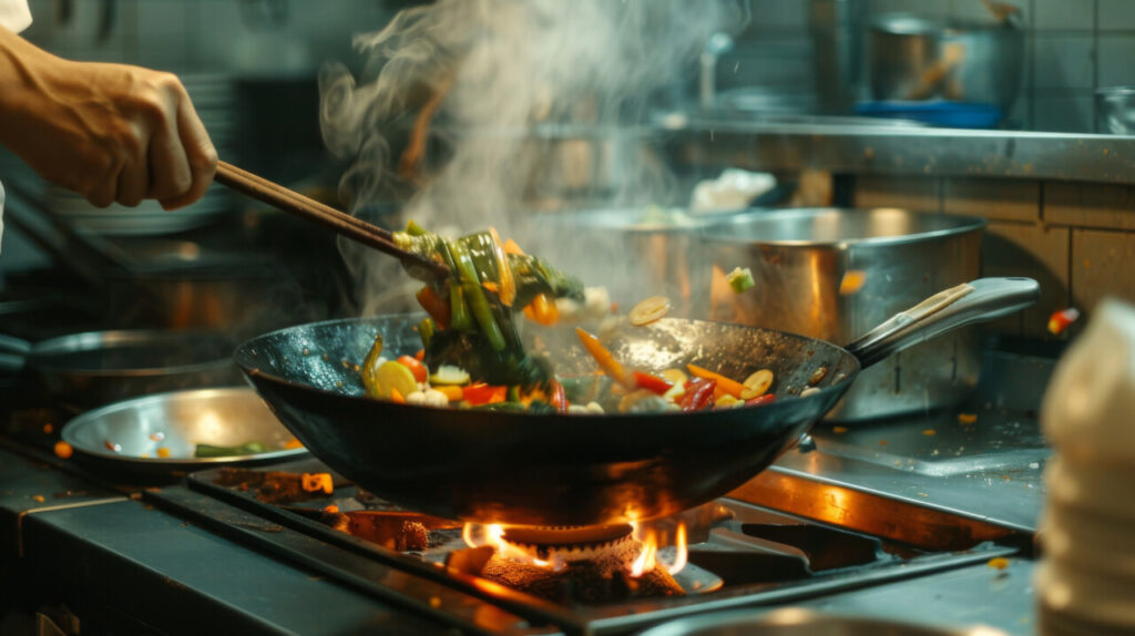 A chef flipping vegetables in a wok over a gas stove, creating a stir-fry dish.