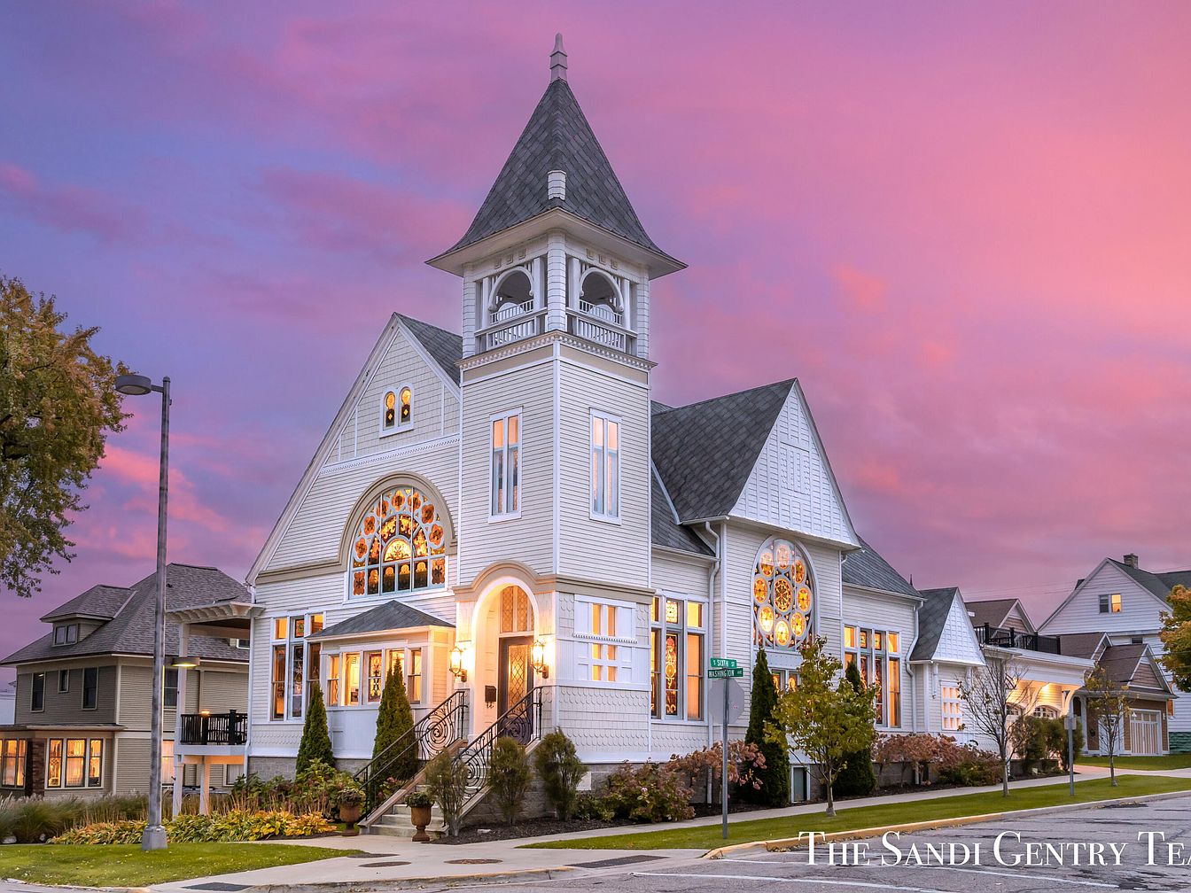 Beautiful 1907 Grand Haven in Michigan With Stained Glass Windows, Soaring Wood-Clad Ceilings, and a Luxurious Pool Oasis