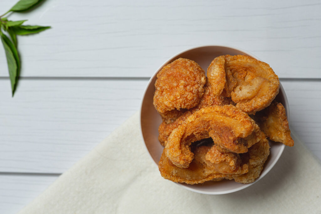 Battered deep-fried pickle slices with dipping sauce on a small tray