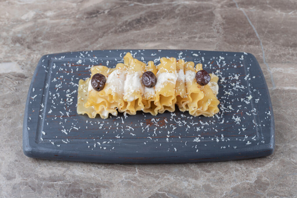 Funnel cake topped with powdered sugar, slightly flattened and oily