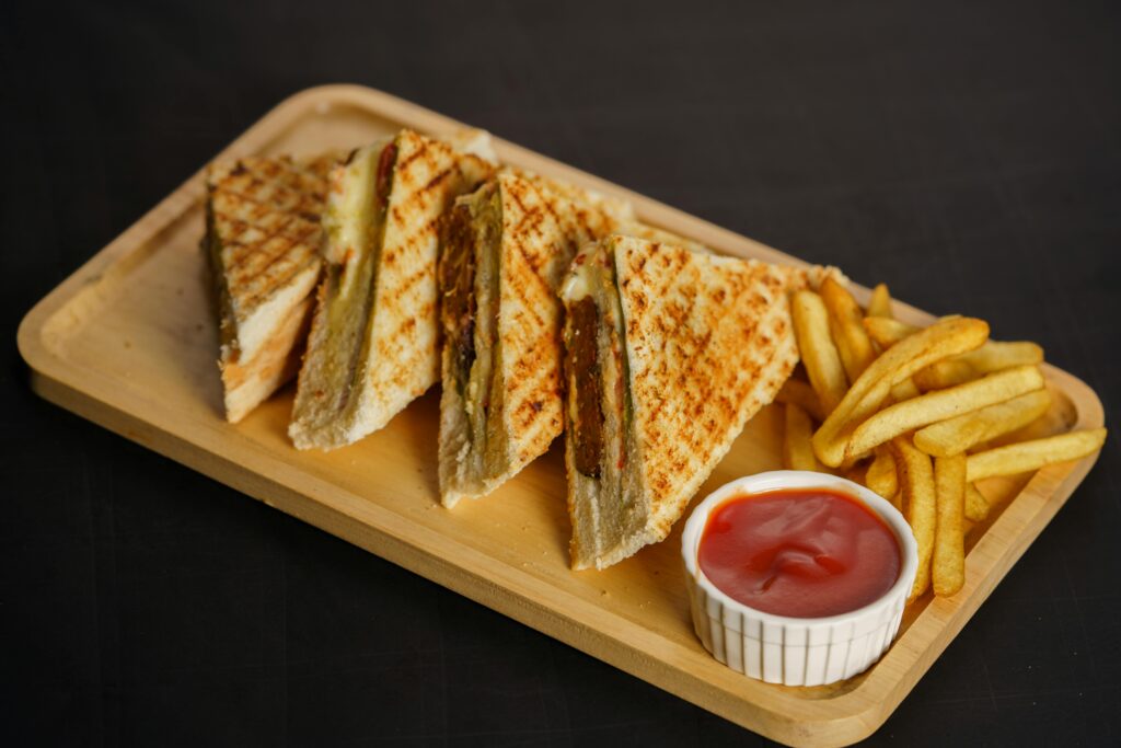 Grilled cheese sandwich cut in half served with a bowl of tomato soup for dipping