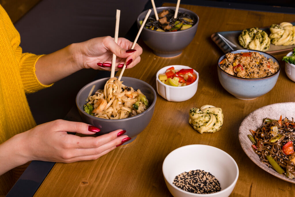 Chinese takeout containers with General Tso’s chicken, fried rice, and lo mein on a kitchen counter