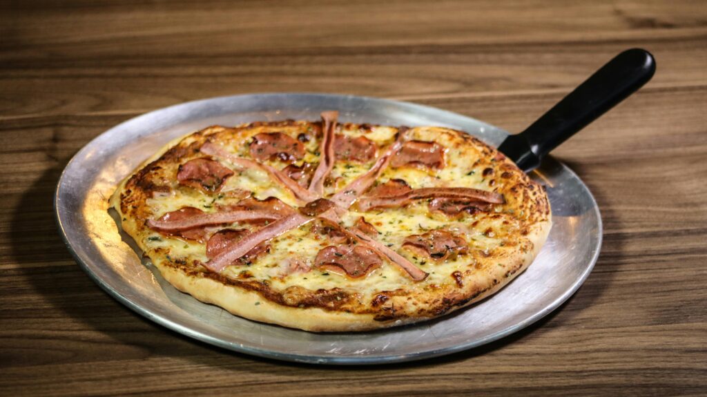 Freshly baked pepperoni pizza with melted mozzarella cheese and golden crust on a wooden table