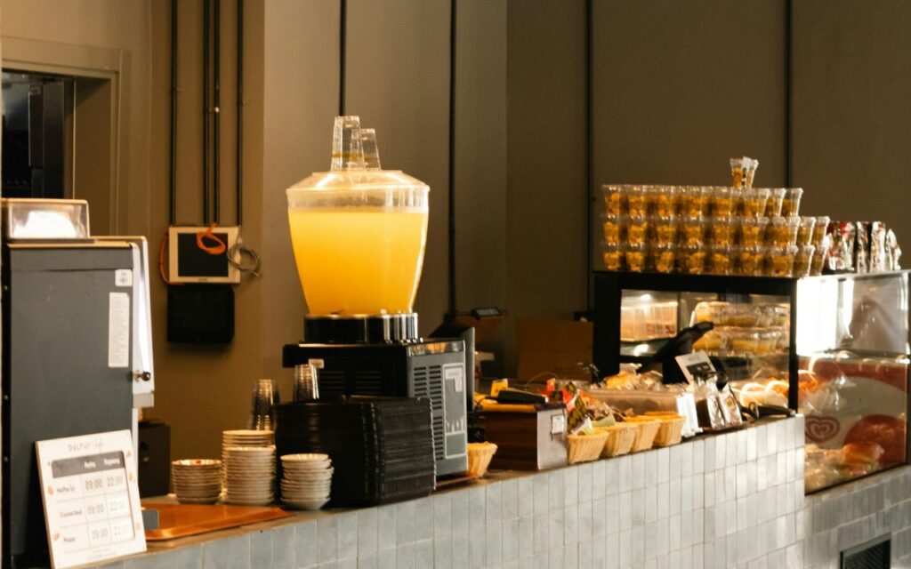 Industrial juice press behind a glass window in a grocery store with oranges being processed