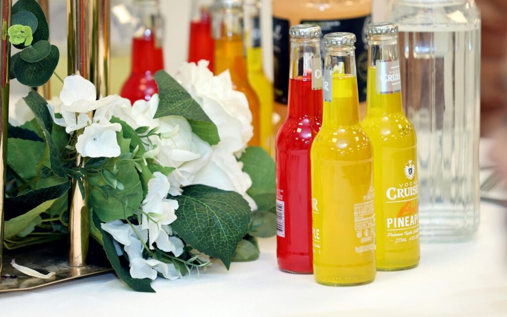 Shopper examining fresh squeezed juice bottles in a grocery case, checking dates and clarity