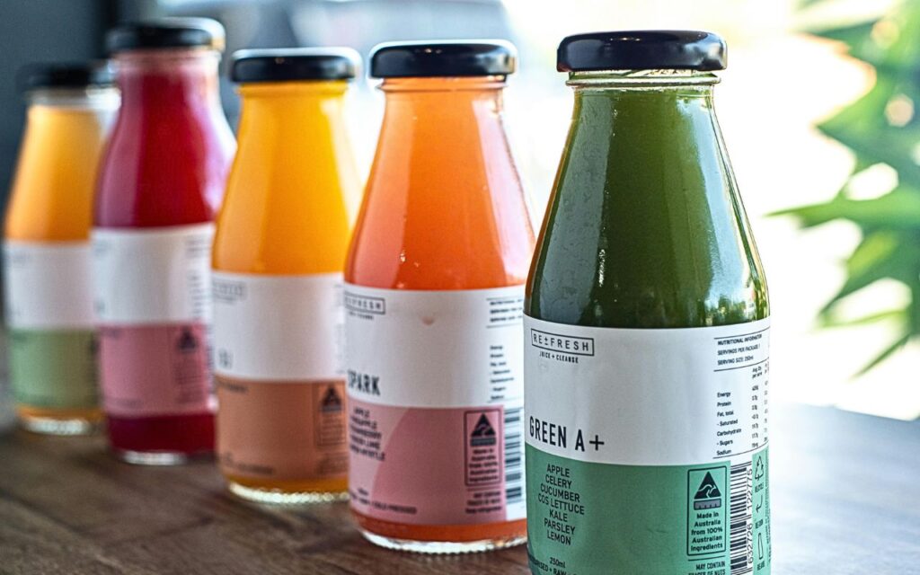 Bottled fresh squeezed juices with fine print nutrition labels and ingredients highlighted
