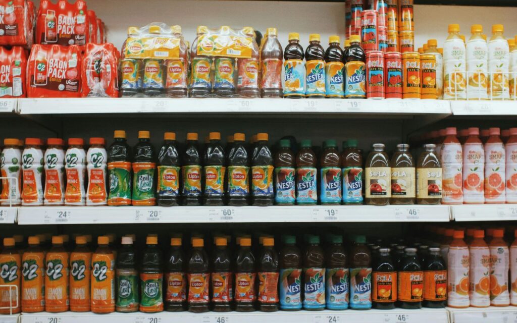 Grocery store juice display with signage indicating “Pressed On-Site” next to standard bottled juice