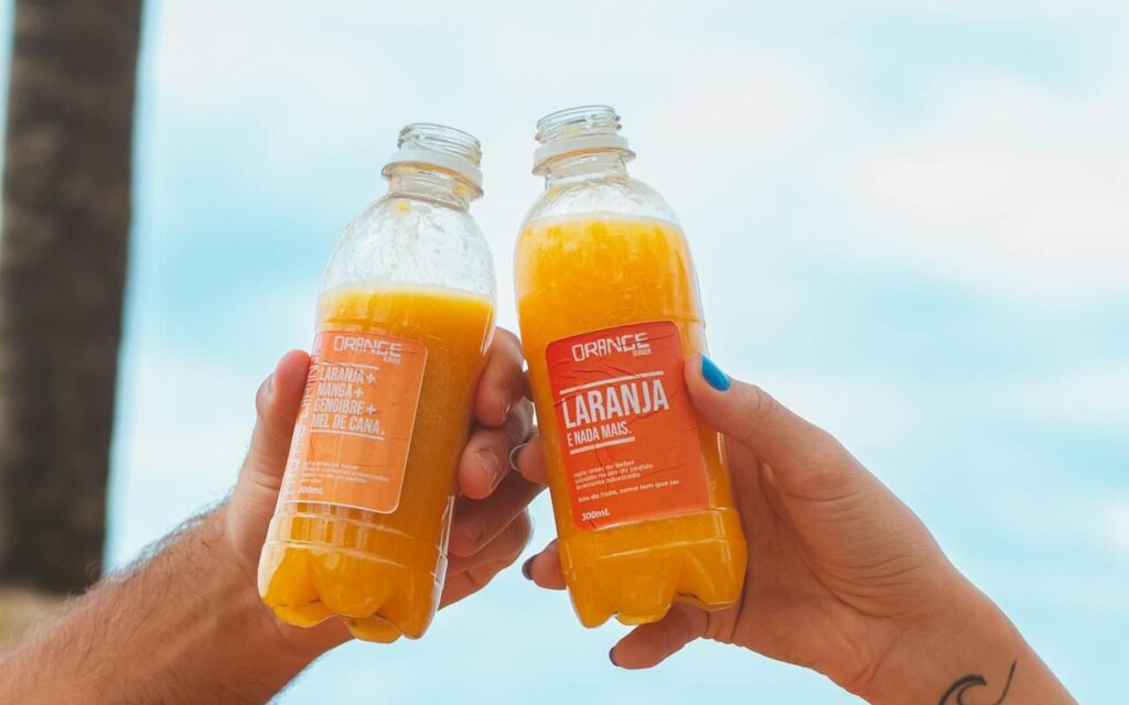 Close-up of a nutrition label on a bottled fresh squeezed juice with citrus in the background