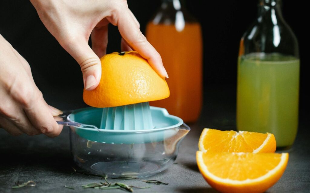 Oranges being mechanically pressed in a large-scale industrial juicing machine