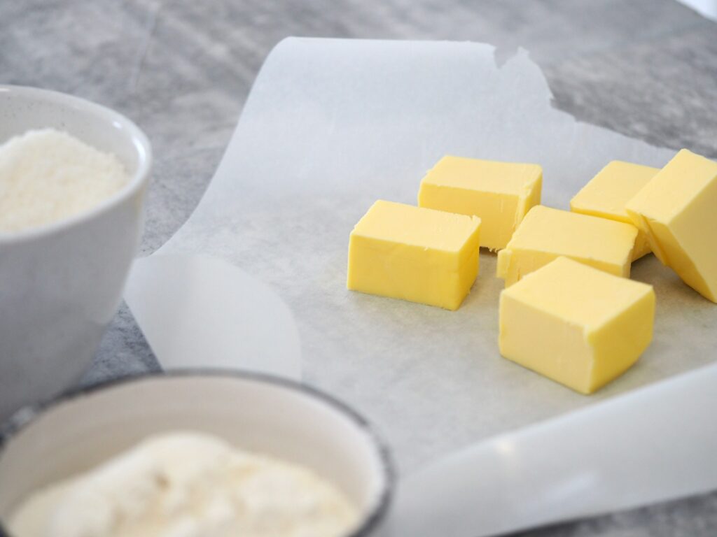 Deep-fried butter square on a small plate with melting butter oozing inside
