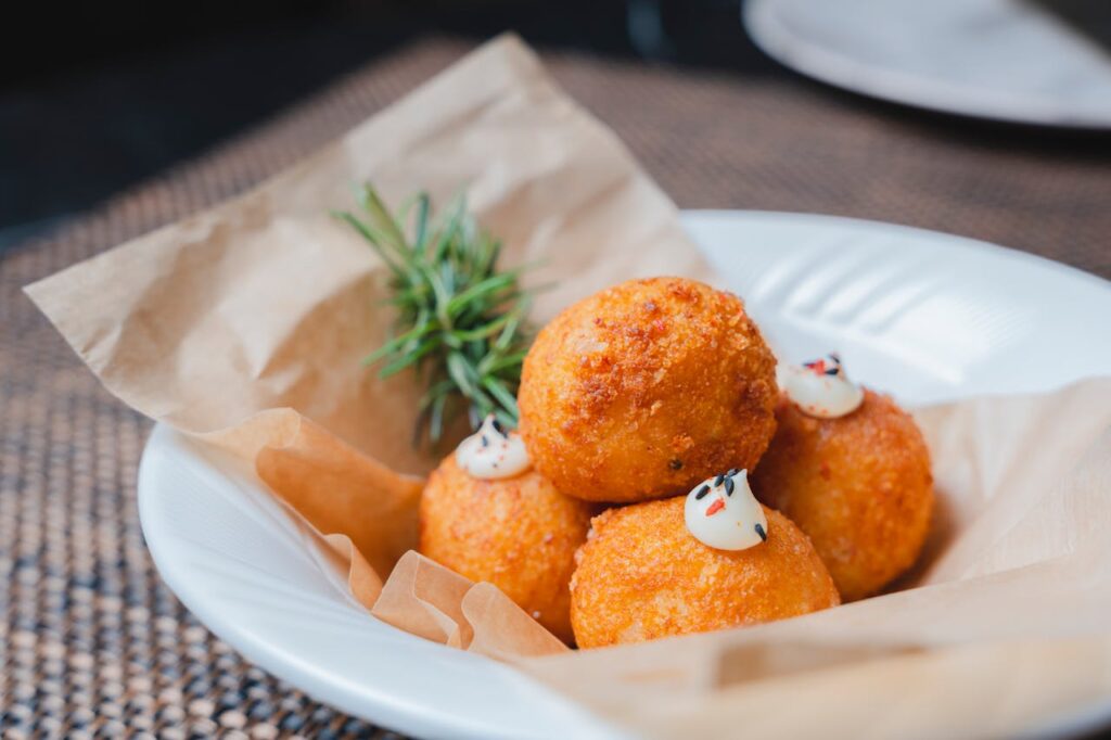 Crispy mac and cheese balls with cheese oozing from broken exterior