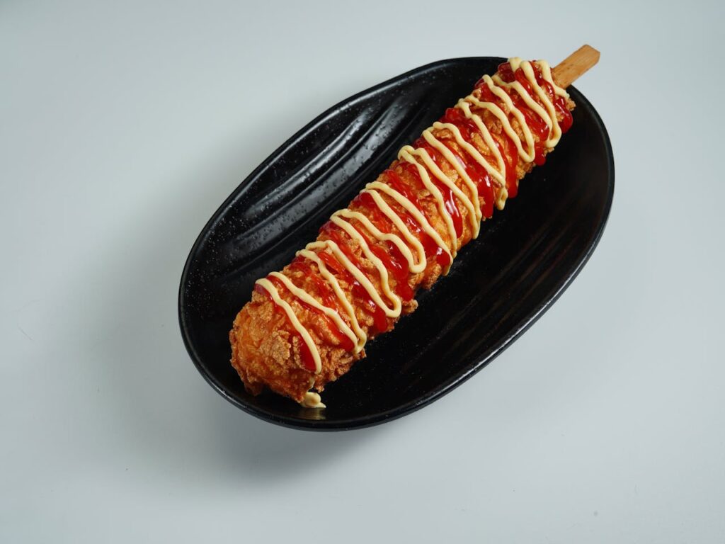 Classic corn dog with thick fried coating on a stick, served at a carnival
