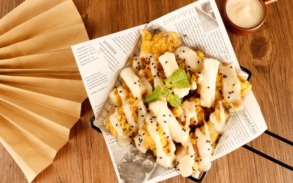 Golden deep-fried Twinkie on a paper plate with slight grease sheen