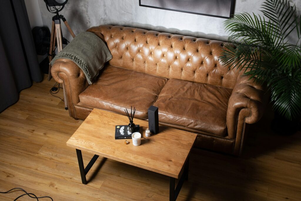 Budget leather sofa with peeling and cracking along armrests in a dry indoor environment