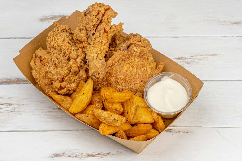Basket of crispy Southern fried chicken with biscuits and coleslaw on a wooden table
