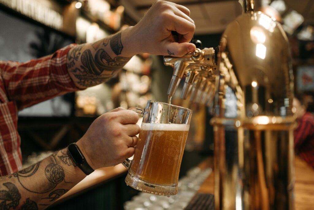A bartender pouring a craft beer from a tap, symbolizing local favorites now available across multiple states