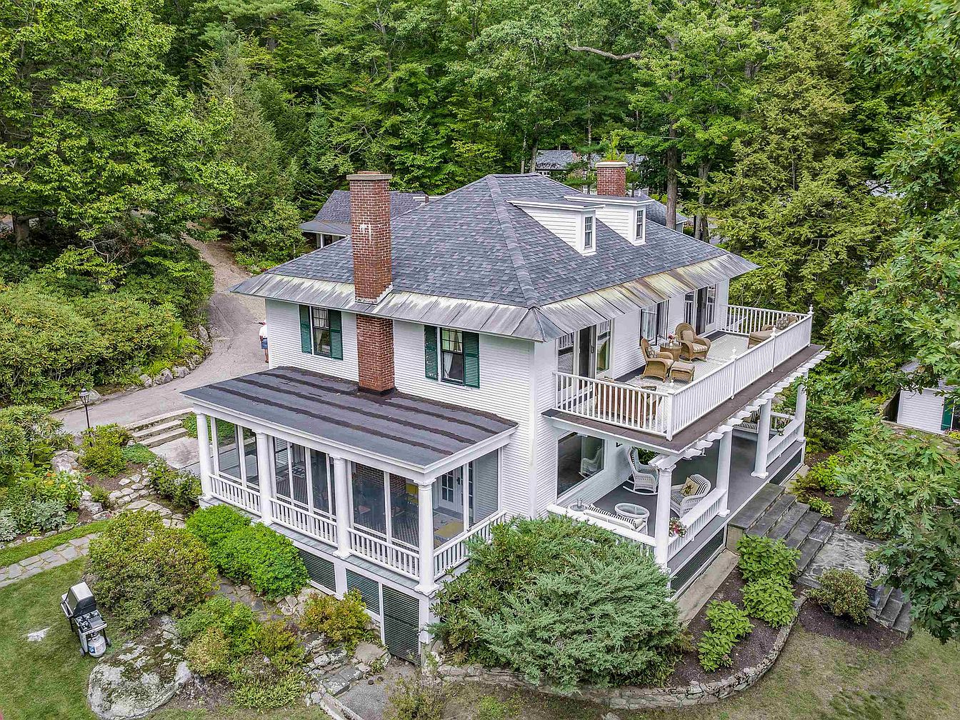 Discover 1910 Colonial Gem in Wolfeboro, New Hampshire with Waterfront Views, a Boathouse, and Cherry Floors Throughout