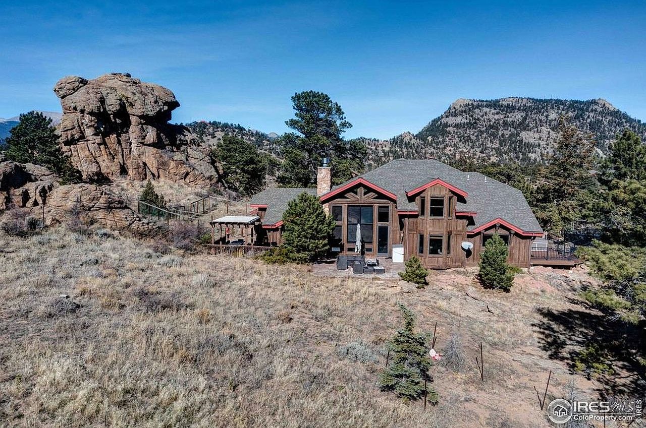 Serene 1994 Mountain Retreat in Estes Park, Colorado Featuring Log-Beamed Ceilings, a Moss Rock Fireplace, and Stunning Views
