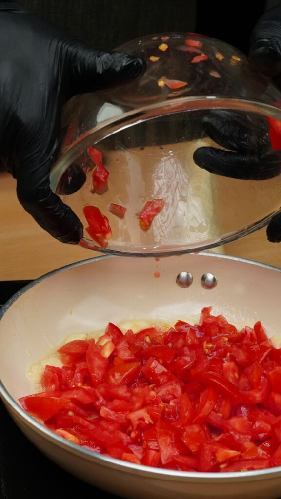 Chopped tomatoes added to the garlic butter