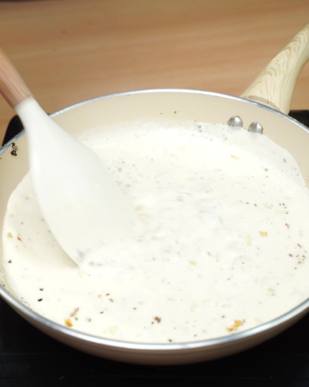 Stirring the smooth garlic Parmesan sauce