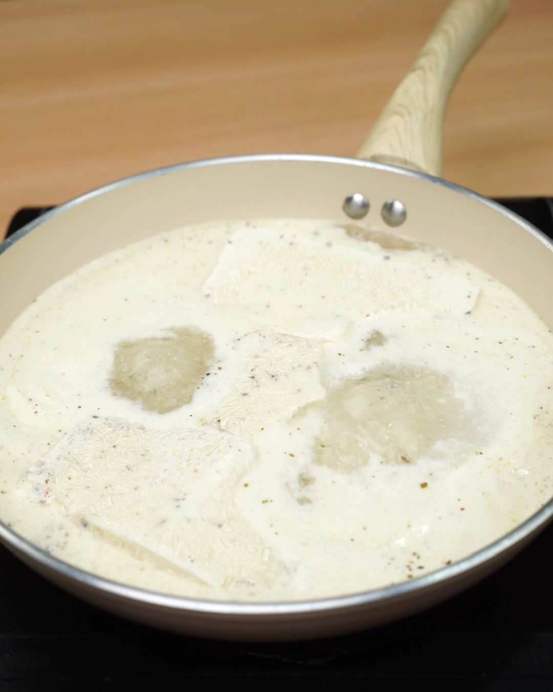Frozen sauce blocks melting into a creamy sauce