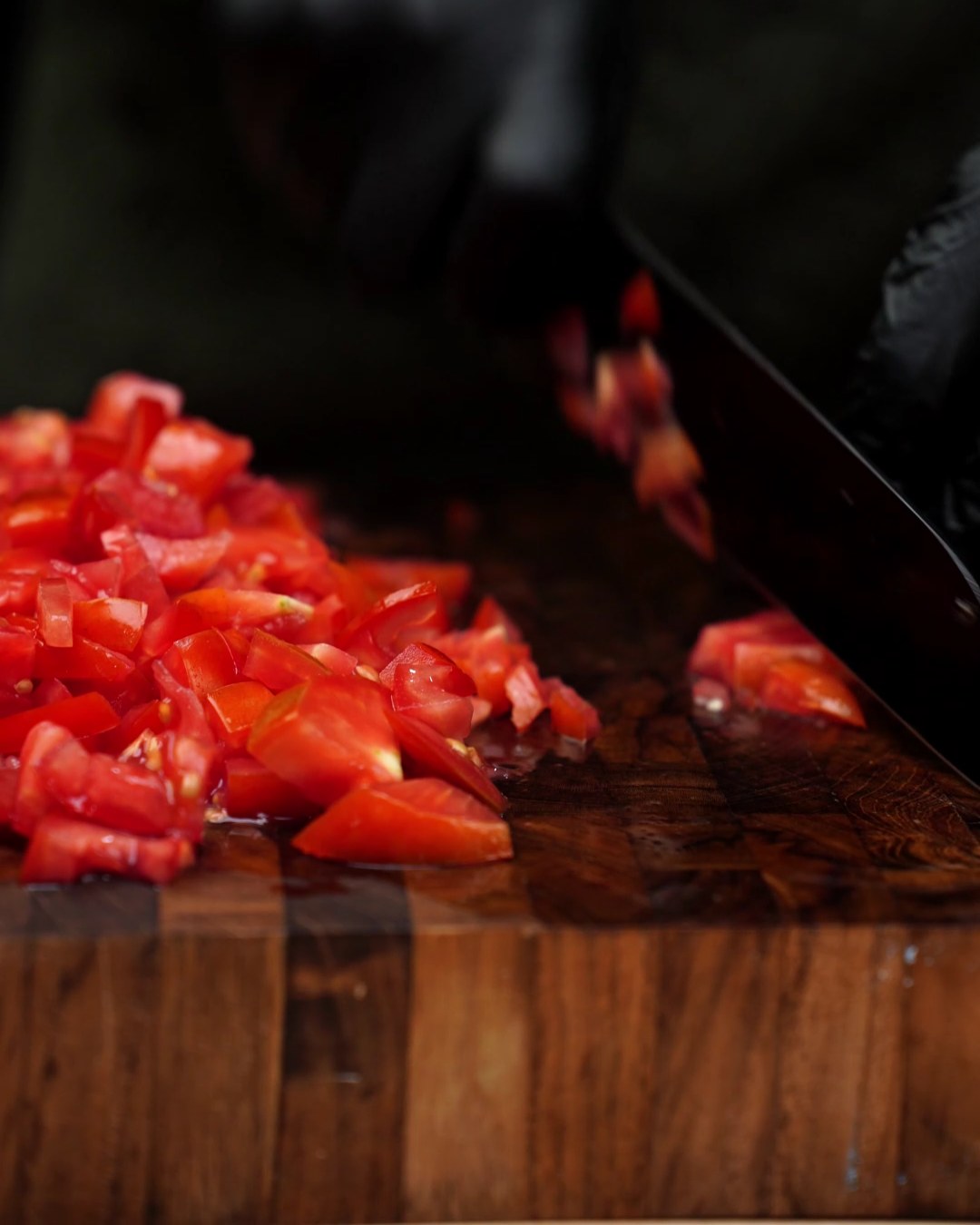 Chopping fresh tomatoes on a wooden cutting board