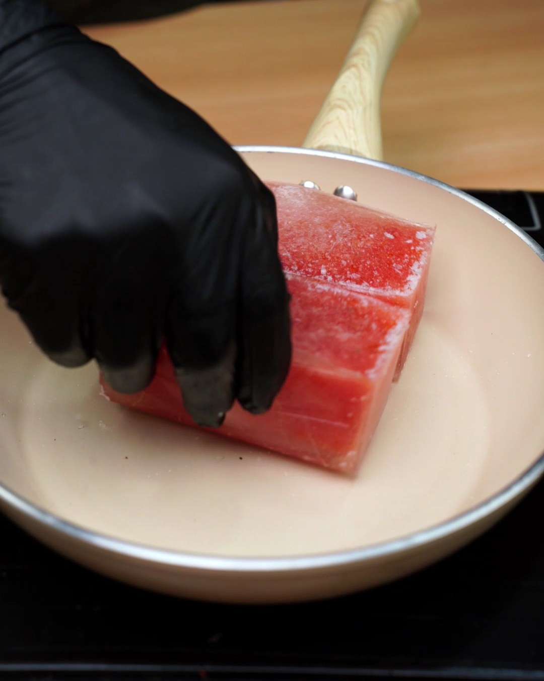 Frozen tomato sauce blocks in a skillet