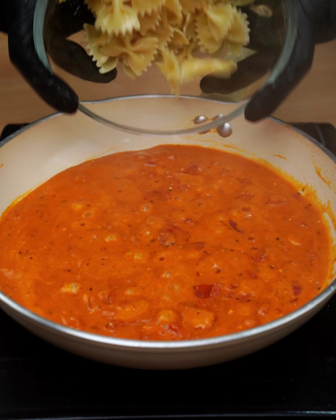 Cooked farfalle added to the creamy tomato sauce