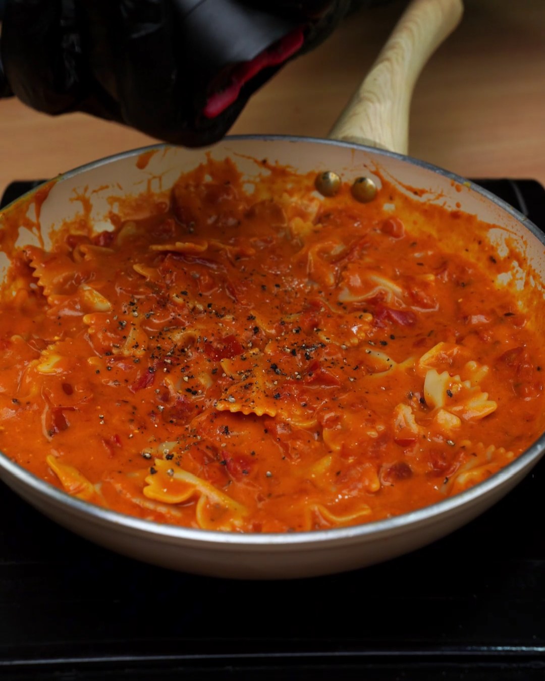 Black pepper ground over creamy tomato bowtie pasta