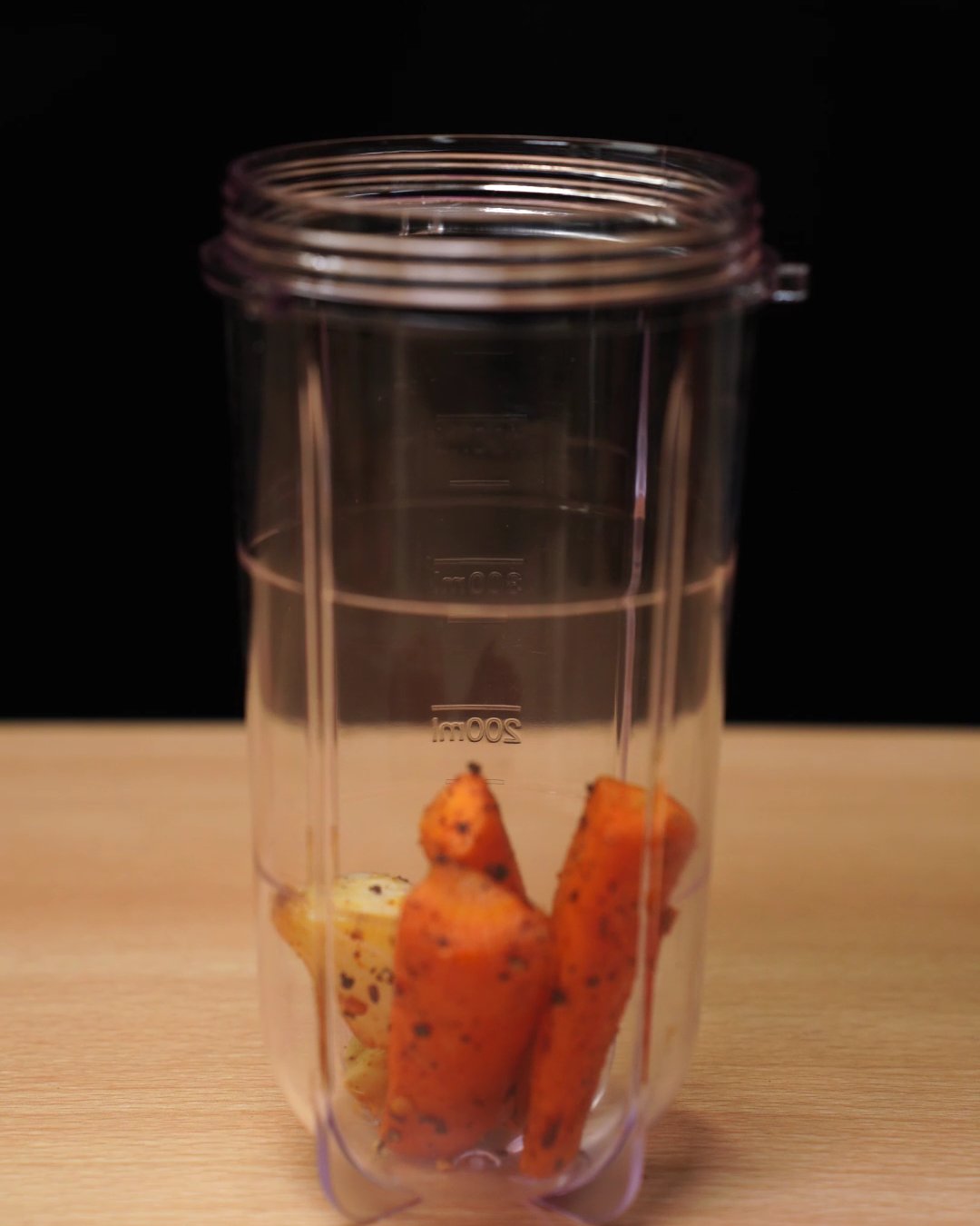 Roasted carrot sticks inside an empty blender cup