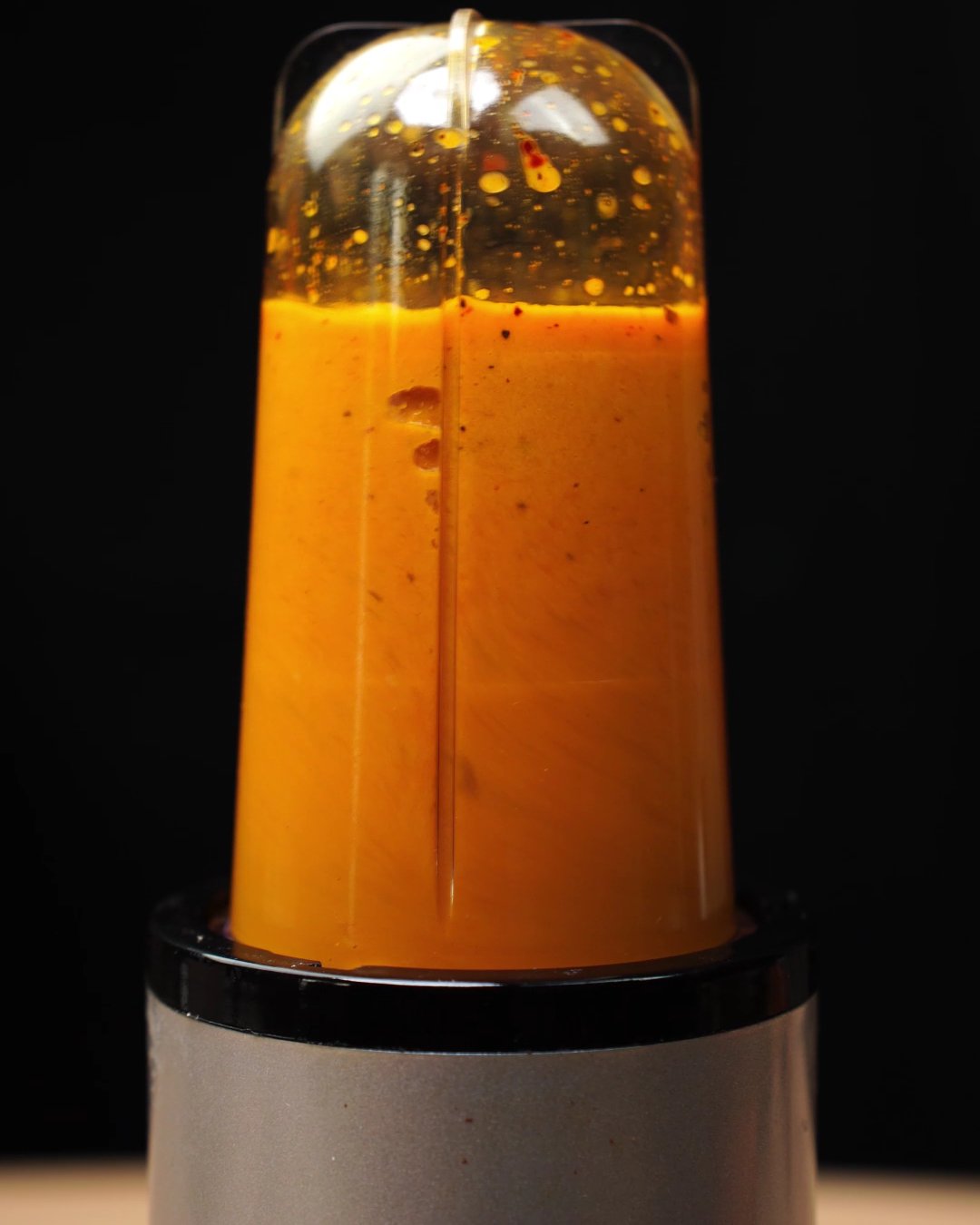 Roasted vegetables blended into a thick orange puree in a blender