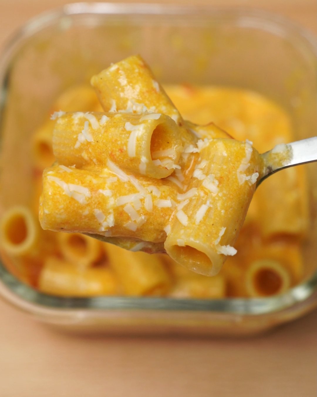 Spoonful of tomato cream rigatoni topped with grated Parmesan