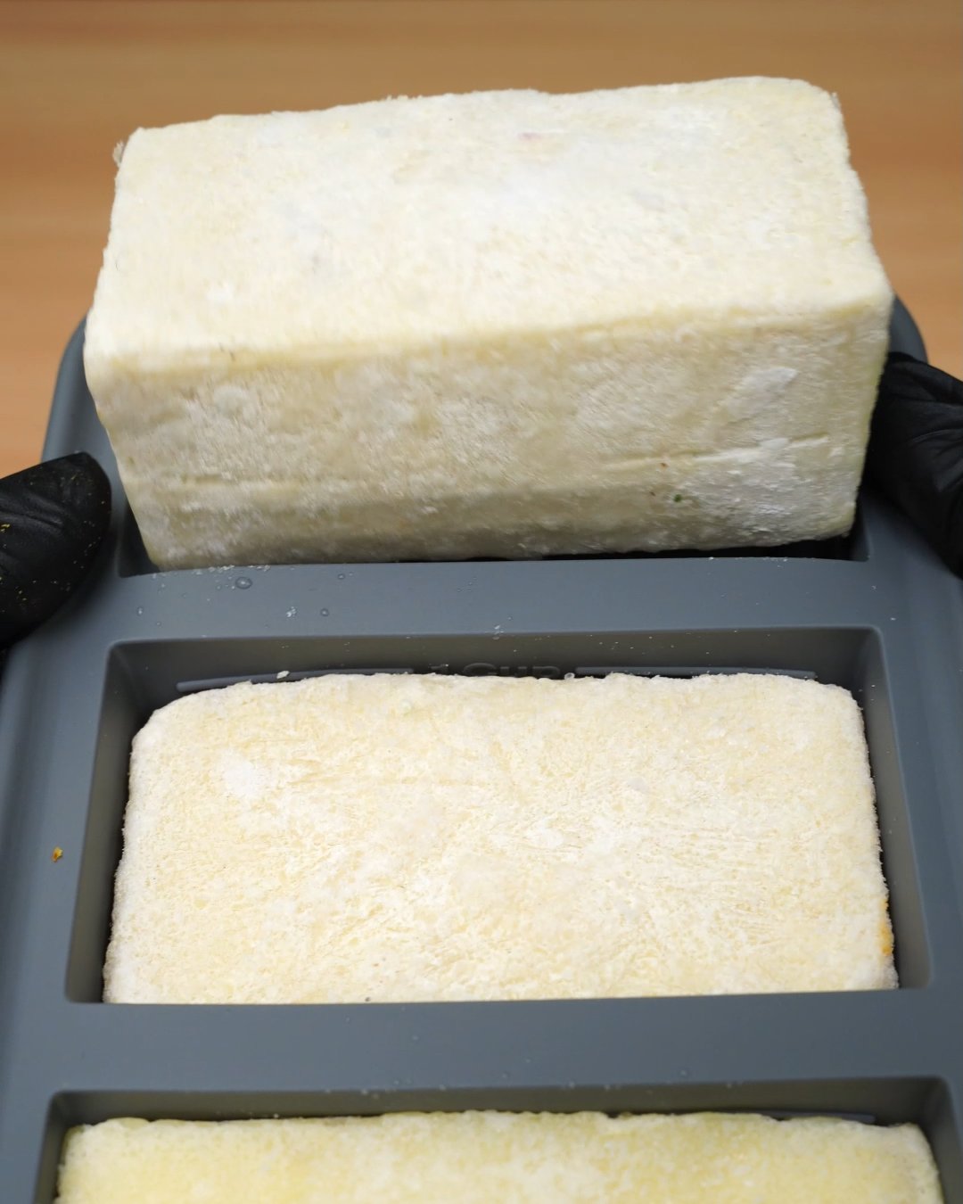 Frozen Alfredo sauce blocks in a gray silicone freezer mold